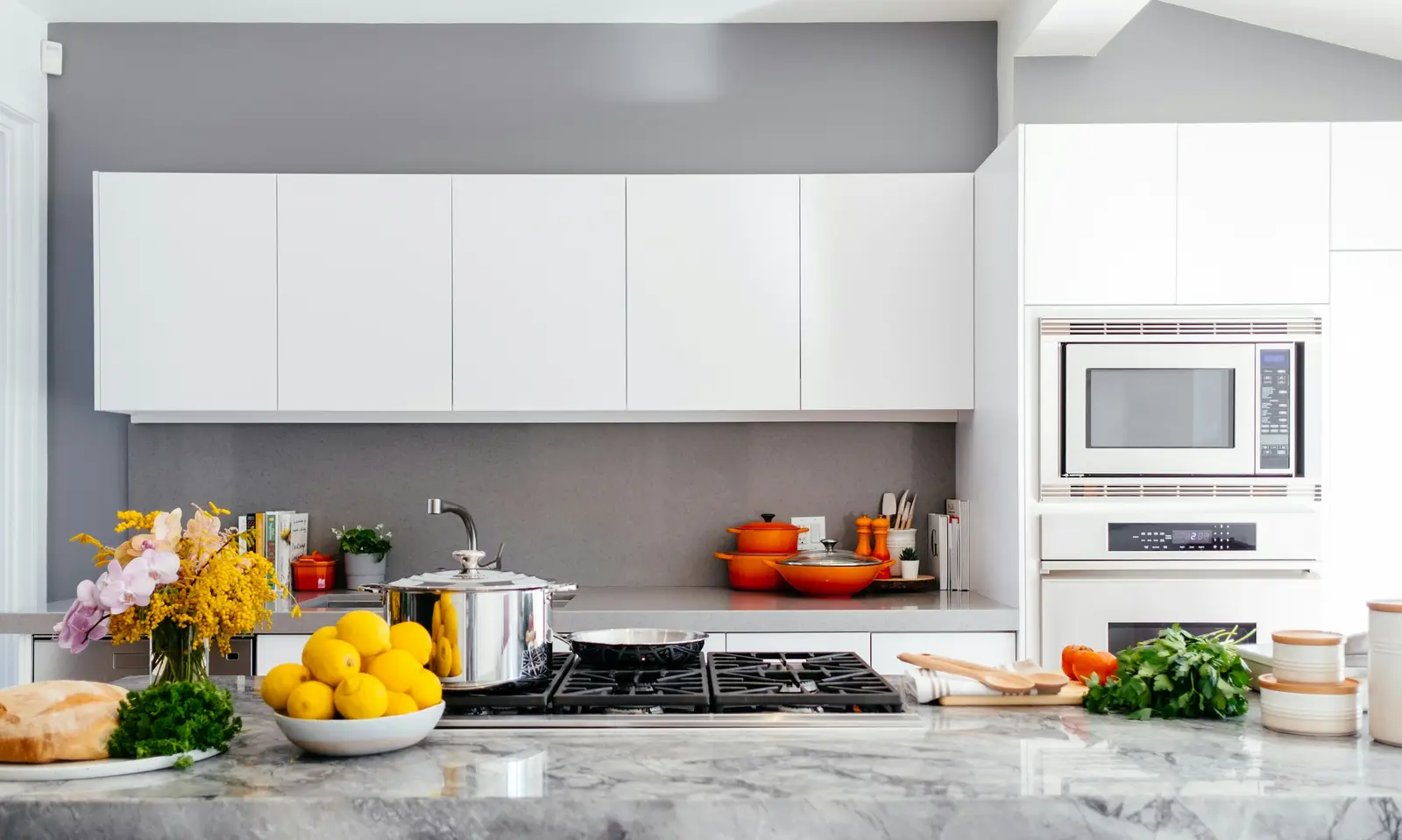 Fresh fruit, vegetables, and cookware on a kitchen counter during meal preparation